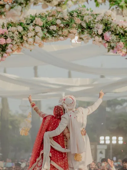 The couple celebrates their union under a beautiful floral arch after the Varmala. This is the moment of pure joy that I strive to create through meticulous planning and execution.