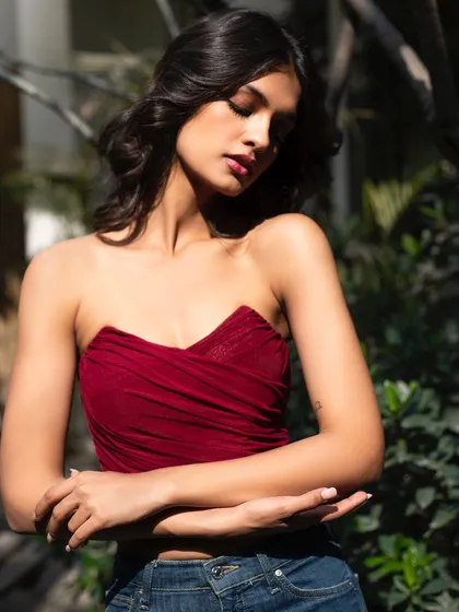 A close-up of the red top, showing the texture and the model's serene expression.