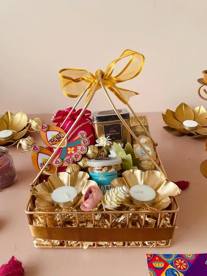 This front-on view of the luxe metal basket highlights its elegant pyramid shape and the abundance of gifts it holds.