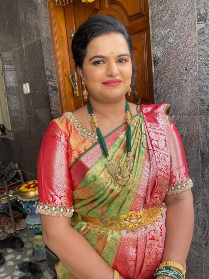 A smiling portrait of Vidhya. The makeup is elegant and timeless, perfect for such a memorable family occasion.