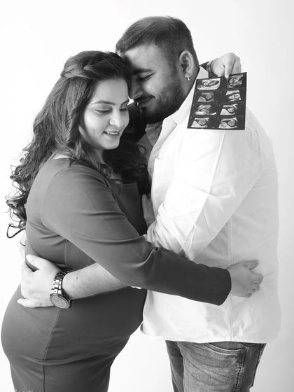 A heartfelt embrace, with the dad to be holding up the first ultrasound pictures. This black and white photo is packed with emotion, telling the story of their journey to parenthood.