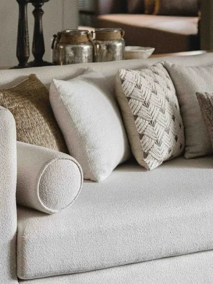 We love layering textures. Here, a variety of cushions in neutral tones with different weaves and patterns adds depth and comfort to a simple, elegant sofa.