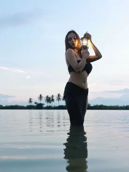 An artistic and sensuous concept shoot at a lakeside. The combination of the water, the fading light, and the single lantern creates a powerful, moody visual that stands out.