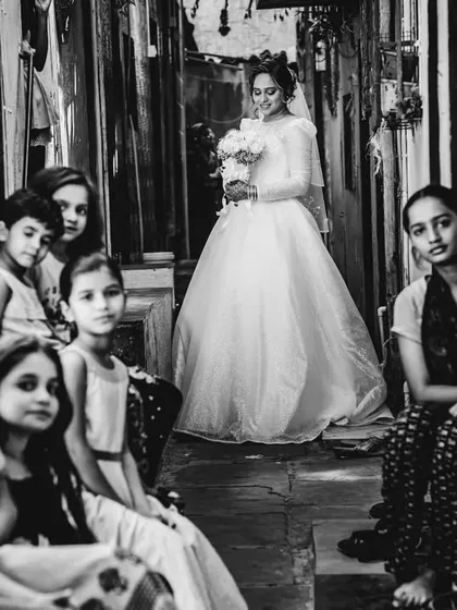 A powerful black and white portrait of the bride in a narrow alley, with local children looking on. This image tells a rich, authentic story.