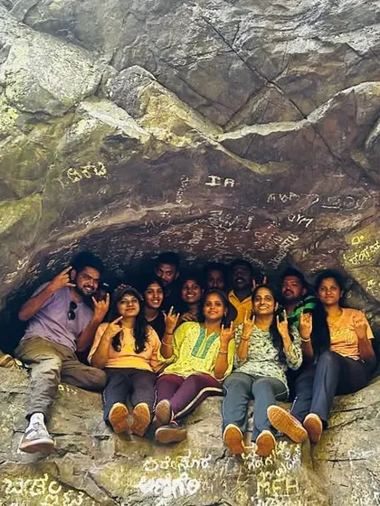 A fun group photo, with trekkers sitting inside a small opening in a rock formation.