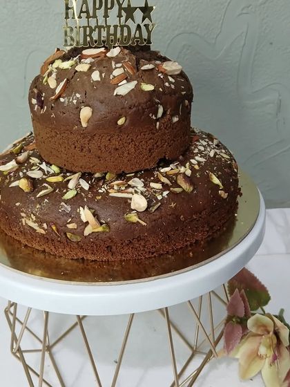 A simple two-tiered dry cake topped with nuts, perfect for tea time.