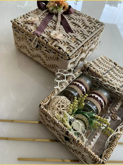 Another view of our beige jute hamper, revealing the contents inside, including decorated glass jars. This is modern gifting with a natural touch.