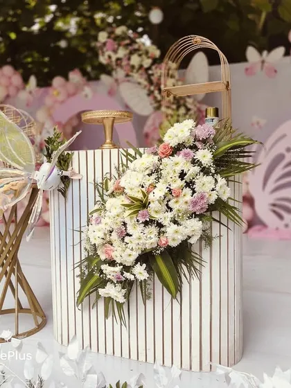 The details make the difference. This close-up shows a trendy fluted table with a lush floral arrangement and delicate fairy wings, highlighting the quality and attention to detail I put into every prop.