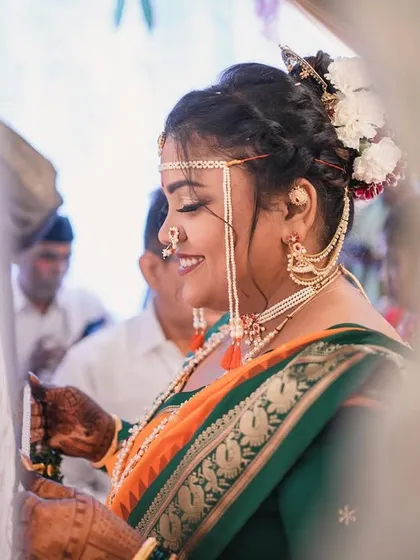 A side profile capturing the intricate hairstyle and the 'mundavalya' during the wedding rituals.