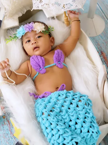 This wider angle of the mermaid theme shows the baby in a boat-like prop with a tiny umbrella, creating a dreamy, nautical scene.