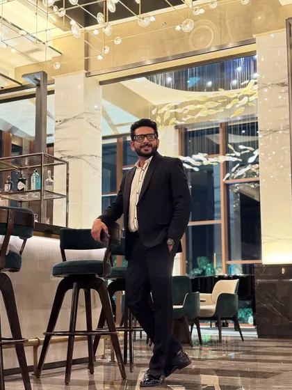 Sometimes, a classic black suit is all you need. Posed at the bar before a formal wedding event, this look is timeless and sharp.