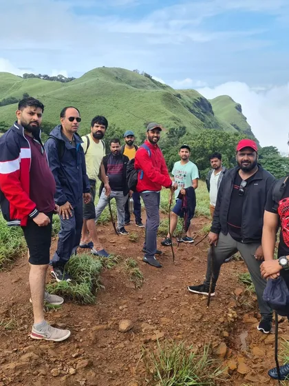 Trekkers on the trail to Bandaje, with the rolling green hills in the background.