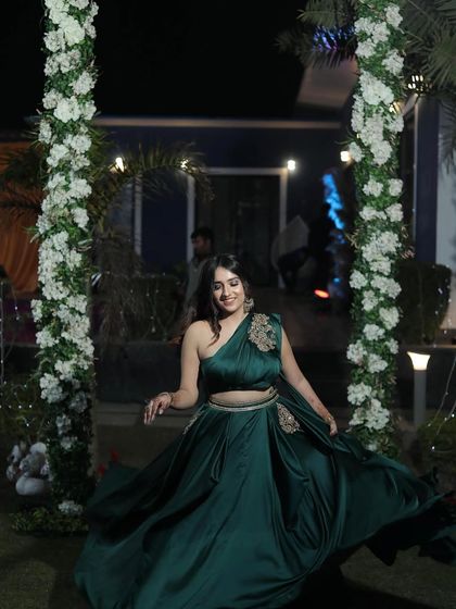 Twirling in a gorgeous emerald green draped gown from The Azmat Official. This kind of dynamic shot is perfect for showing the flow and fabric of an outfit.