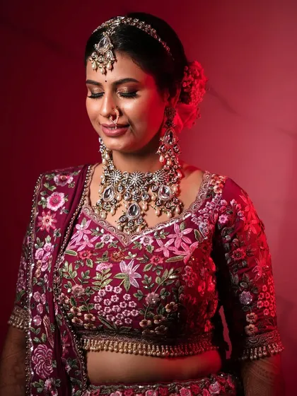 The bride looking down, showcasing the beautiful details of her eye makeup and heavy bridal jewelry.