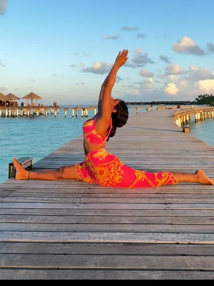 A full expression of Hanumanasana on a pier at sunset. The perfect setting for a deep hip opener.