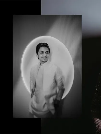 A black and white groom portrait using a circular light for a modern, graphic effect.