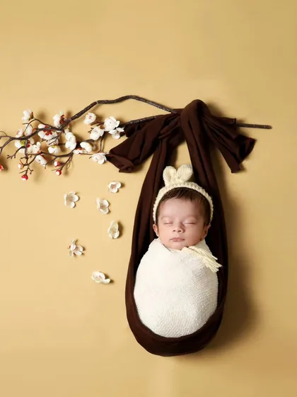 The hanging sling pose is a composite image, meaning the baby is safely supported at all times. It creates a beautiful, artistic photo that looks like the baby is floating peacefully.