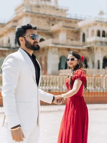 A candid moment of the couple holding hands and walking in front of Albert Hall Museum, capturing their natural interaction and style.