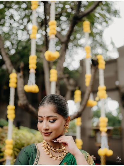 A delicate and beautiful close-up. This shot focuses on the bride's features and the intricate details of her traditional jewelry.