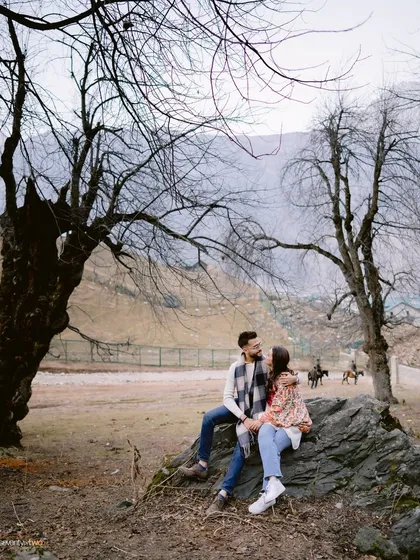 Framed by the stark, beautiful trees of a Kashmiri winter, they share a look. The world around them is quiet, making their connection the focal point of the entire scene.