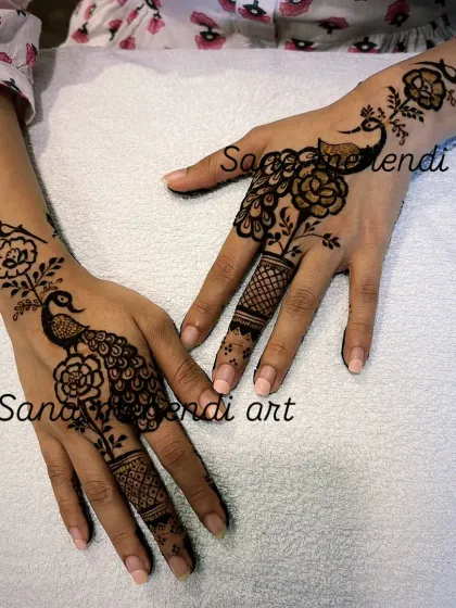 For a simple yet elegant look, I created this Arabic-style design with graceful peacocks and floral vines on the back of the hands. It's a beautiful choice for any festival where you want a lighter, stylish design.