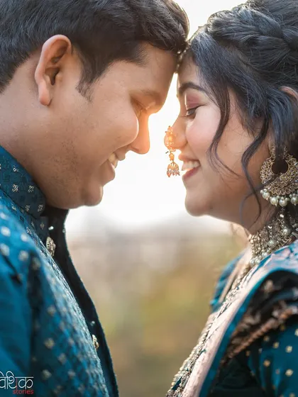 Golden hour light adds a layer of magic to any portrait. We captured this couple in a close, intimate pose, letting the setting sun create a warm, romantic flare that highlights their connection and the soft details of the bride's makeup and jewelry.