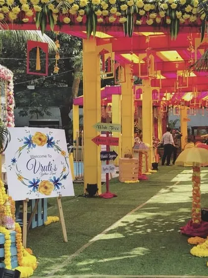 Welcome your guests to the Haldi ceremony with a burst of color. This vibrant entrance uses traditional marigold garlands, bright yellow and pink structures, and a personalized welcome sign to create a cheerful and festive atmosphere.