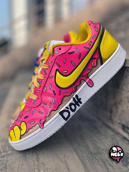 A single shot of the pink donut shoe, giving a clear view of the sprinkle pattern and the dripping design over the "D'oh" text.