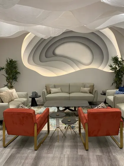 The innovative iLounge designed for the IDAC Expo, showcasing parametric design principles. A sculptural wall feature with integrated lighting serves as the focal point, while the fluid fabric ceiling creates an immersive and illusory spatial experience.