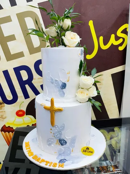 This elegant two-tiered Baptism cake is designed with fresh white roses and subtle gold accents. It's a beautiful centerpiece for a sacred family celebration.