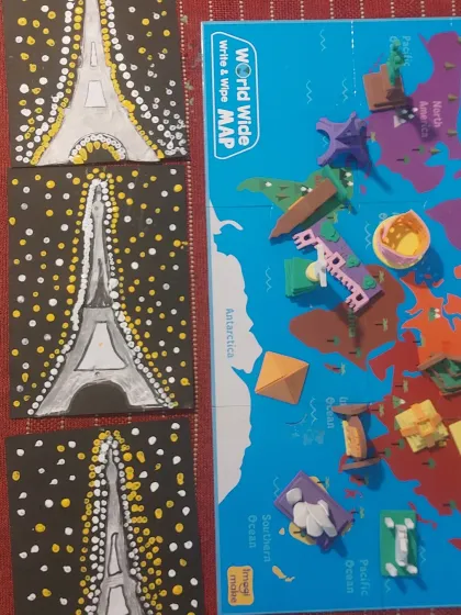 A close-up of the Eiffel Tower dot paintings next to the world map puzzle. We blend art with geography to make learning visual and fun.