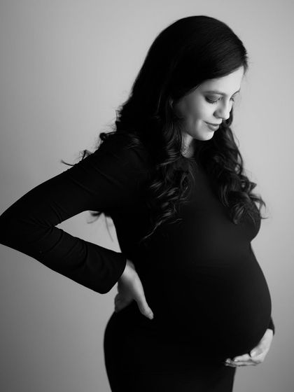 A serene and beautiful black and white portrait. The way she holds her back while cradling her bump is such a real and relatable gesture of late pregnancy.
