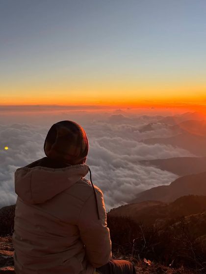 A quiet moment of reflection, watching the sun paint the sky above the clouds at Sandakphu. These are the peaceful, personal moments that make Himalayan treks so special.