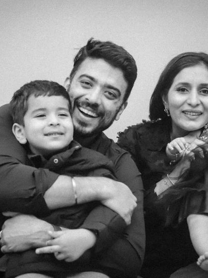 A happy black and white family portrait. Dad is holding his son, and mom is holding their baby girl.