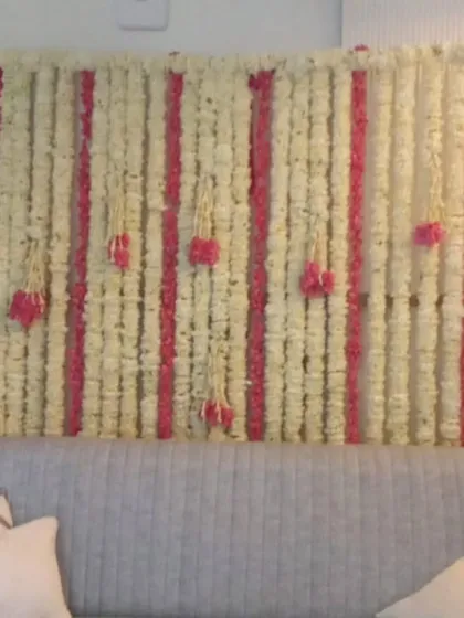 A beautiful floral wall made of white and pink flower strings. This elegant and fragrant backdrop is perfect for a ring ceremony, Mehandi, or even as a photo booth.