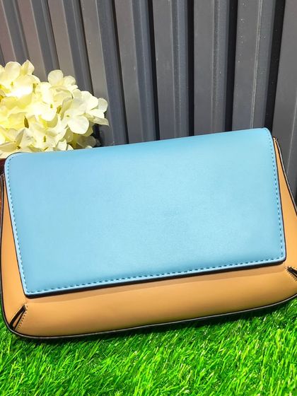 A modern color-blocked clutch in sky blue and tan. This is a great piece for a daytime event or to add a pop of color to a simple outfit.
