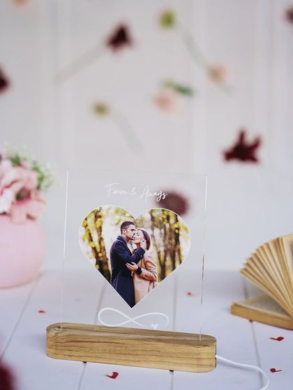 A heart-shaped LED night lamp featuring a couple's photo and the message 'Forever & Always'. The soft glow creates a warm and romantic ambiance.