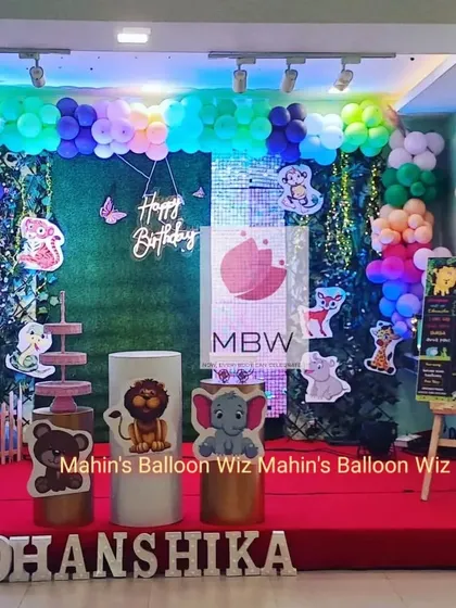 A woodland animal-themed first birthday with a unique twist. I used a greenery and shimmer panel backdrop, a colorful balloon garland, and cute animal cutouts to create a magical forest setting.