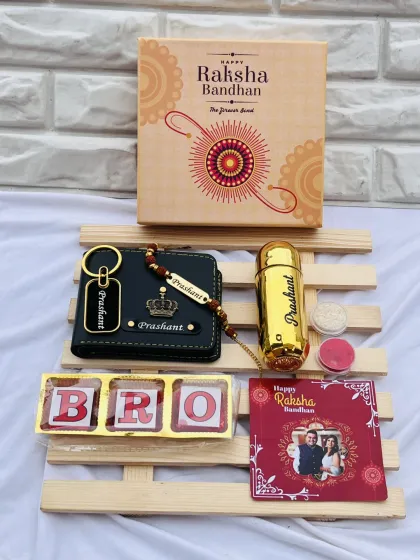 This Rakhi gift set features a "BRO" chocolate box, a personalized wallet and keychain, a custom perfume bottle, and a photo card, all beautifully arranged on a wooden platter.