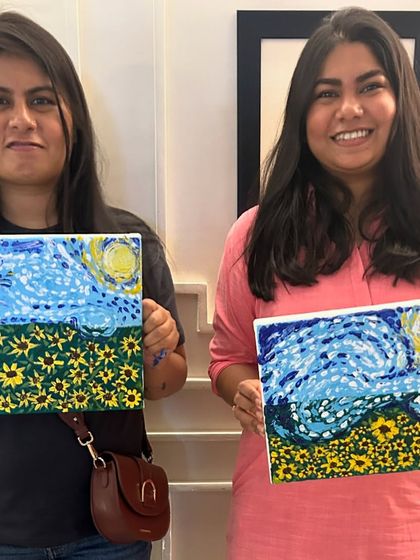 Two participants proudly displaying their unique versions of a Van Gogh-inspired sunflower field. It's amazing how everyone adds their own personal touch.