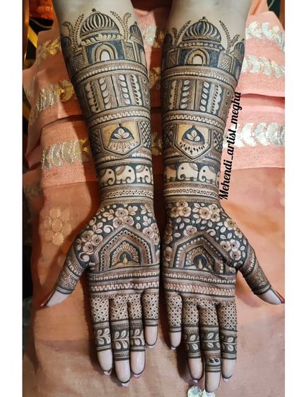 A grand design with architectural domes on the arms and floral archways on the palms. This mehendi has a very regal and structured feel.