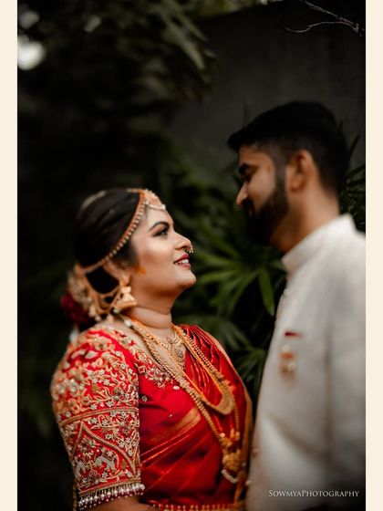 A beautiful close up of the bride looking lovingly at her groom. Her intricate red saree, makeup, and traditional jewelry are all captured in stunning detail.