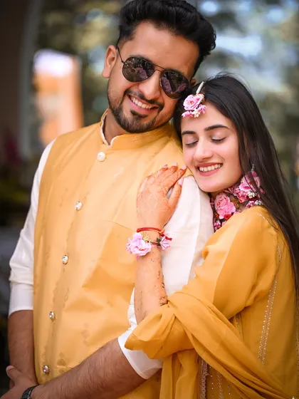 A happy, relaxed portrait of the couple, their yellow outfits perfectly matching the vibrant Haldi theme.