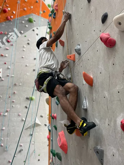 A climber tackles a challenging route on our main wall, showing the height and scale of our facility.