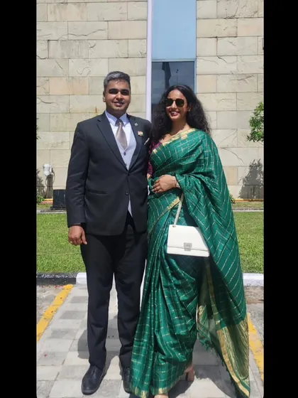 A classic look for a formal event. I chose this beautiful emerald green saree with subtle gold stripes, paired with a simple white handbag. This shows how I can create a sophisticated and timeless wedding guest style that is both graceful and eye-catching.