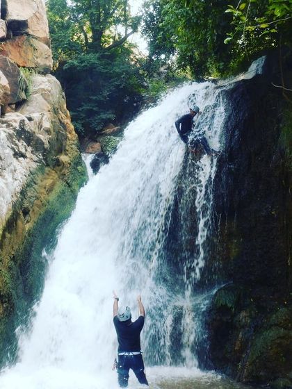 An instructor signals to the rappeller above, demonstrating clear communication which is vital during any descent.