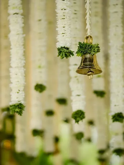 It's the small details that bring a design to life. This close-up shows fragrant white tuberose garlands and a traditional golden bell, elements I frequently use to add authentic charm and sensory richness to my South Indian wedding decor.