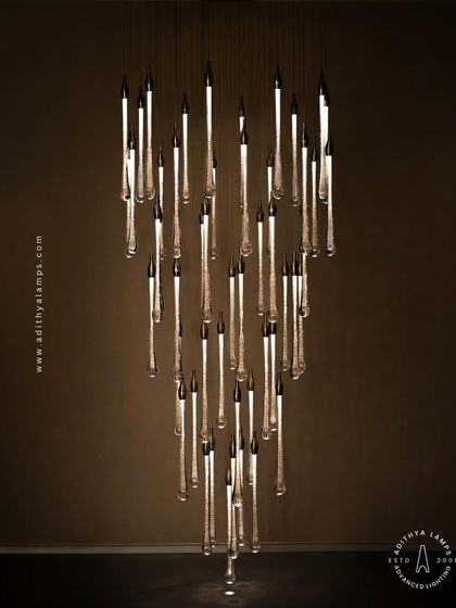 A stunning cluster of crystal teardrop pendants. Each pendant contains bubble-like inclusions that catch the light, creating a sparkling, rain-like effect. This is an elegant choice for double-height foyers or modern staircases.