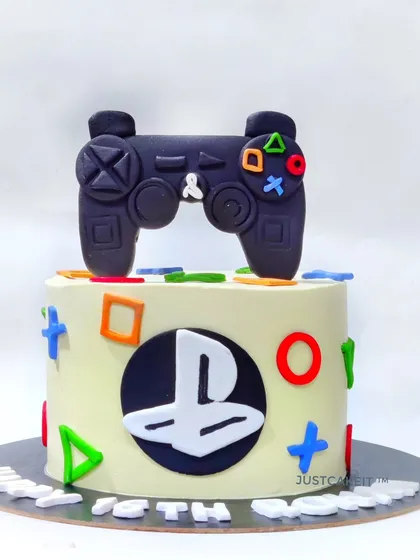 A sleek PlayStation theme cake for a gaming enthusiast's 18th birthday. It features a handmade, edible controller and the iconic button symbols for a clean and modern design.
