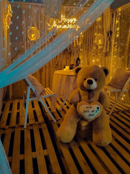 I design intimate and romantic settings like this "Macrame Bliss" anniversary surprise. The warm glow of fairy lights, neon signs, and cozy boho details create a perfect private celebration for two, whether it's on a rooftop or in your backyard.